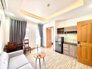 a living room with a couch and a tv at Blue Sea Luxury Hotel & Apartment Vũng Tàu in Vung Tau