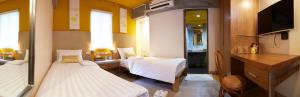 a small room with two beds and a kitchen at Uncle Loy's Boutique House in Bangkok
