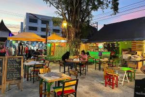 a group of people sitting at tables in a restaurant at Bed Station Hostel Krabi in Ban Khlong Chi Lat