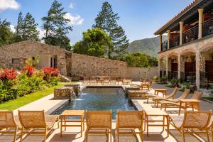 a patio with chairs and a pool and a building at Hotel La Compania Del Valle in Valle de Anton