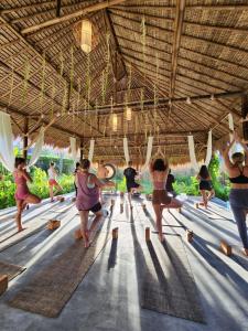 a group of people doing yoga in a building at Jivana Resort in Kuta Lombok
