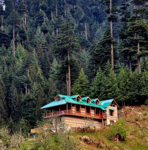 a house with a blue roof on top of a hill at Khwabgaah Manali in Manāli