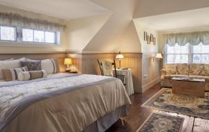 een slaapkamer met een groot bed en een stoel bij Isaiah Jones Homestead Bed and Breakfast in Sandwich