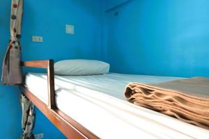 a bed in a room with a blue wall at Bed Station Hostel Krabi in Ban Khlong Chi Lat
