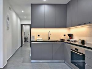 a kitchen with gray cabinets and a sink at Kilada Luxury Apartment 1 in Kilada