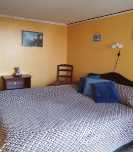 a bedroom with a bed with blue pillows at Departamento Estudio Viña del Mar in Viña del Mar