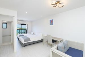 宮古島にあるHotel & Villa Seahorse MIYAKOJIMAの白いベッドルーム(ベッド1台、テーブル付) +37枚の写真