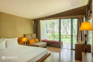 a bedroom with a bed and a couch and a window at Flamigo Dai Lai Resort - Villa Chủ Tự Doanh in Ngọc Quang +161 photos