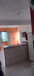 a kitchen with orange walls and a counter top at Cantinho Feliz in Arraial do Cabo