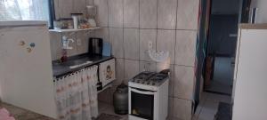 a small kitchen with a stove and a sink at Cantinho Feliz in Arraial do Cabo