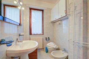 a white bathroom with a sink and a toilet at Appartamento Il Rio - Happy Rentals in Sauze d'Oulx