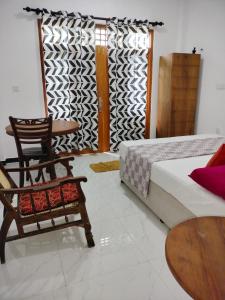 ein Schlafzimmer mit einem Bett, einem Stuhl und einem Tisch in der Unterkunft Laveranda Apartment ground floor and laverenda apartment upstairs in Nikawatawana