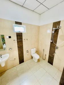 Un baño con ducha, inodoro y lavabo. en Kumbuk Sewana Villa, en Anuradhapura