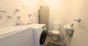 a white bathroom with a toilet and a sink at Dana-Central Apartment with Mount Ainslie Views in Canberra