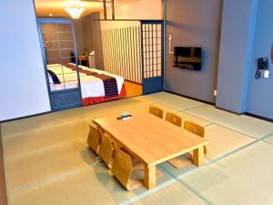 沖縄市にあるライカムファミリーリゾートホテル旧HiyagunLanaiResortのテーブル、椅子、ベッドが備わる客室です。