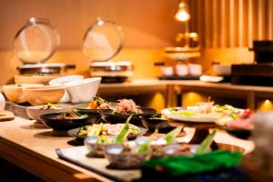 a buffet with plates of food on a table at Hotel SUI Kyoto Kiyomizu in Kyoto