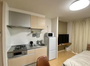 a small kitchen with a stove and a refrigerator at Bliss金池 in Oita