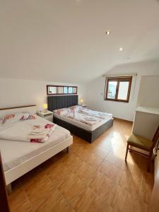 a bedroom with two beds and a chair in it at Apartment Eli Kacjak in Dramalj