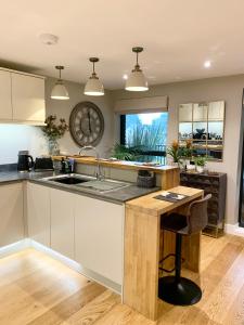 a kitchen with a sink and a clock on the wall at #8 Brunel House Luxury Apartment in Great Malvern in Great Malvern