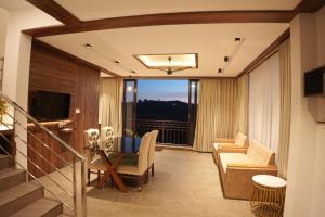 a living room with a couch and a table at Golden Meadows Resort By Dwellsmith Virtue in Vagamon