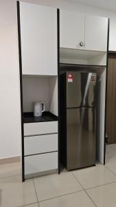 Bandar PenawarにあるCasaBella Desaru by Aininazのキッチン(ステンレス製の冷蔵庫、白いキャビネット付)
