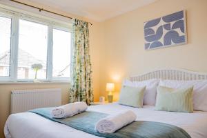 a bedroom with a large white bed with two pillows at Stylish 3-Bed, Garden & Secure Parking - M5 5 mins in Hindlip