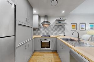 a kitchen with white cabinets and a sink at Tidal Haven in Noosaville