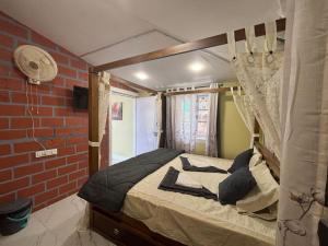 1 dormitorio con cama con dosel y pared de ladrillo en The Plum Castle, en Kodaikanal 76 fotos más