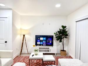 Una sala de estar con televisión y un sofá. en GilmoreOne, en Van Nuys