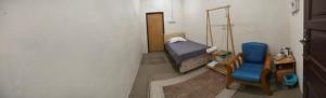 a small room with a bed and a chair at KASMA HOMEsTELs in Kampong Permaisuri