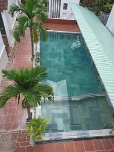 ein leerer Pool mit zwei Palmen darin in der Unterkunft Familia Resort in Phu Quoc