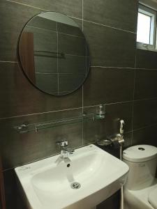 ein Badezimmer mit Waschbecken, Spiegel und Toilette in der Unterkunft Familia Resort in Phu Quoc