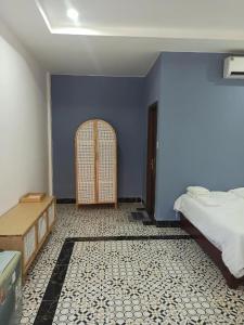 Schlafzimmer mit blauen Wänden, einem Bett und einer Tür in der Unterkunft Familia Resort in Phu Quoc