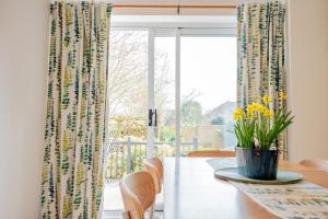 a dining room with a table and a window at Stylish 3-Bed, Garden & Secure Parking - M5 5 mins in Hindlip