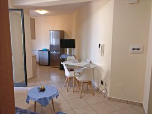 a kitchen with a table and chairs in a room at 1Appartamento sulla spiaggia in Spadafora