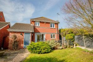 a red brick house with a fence in the yard at Stylish 3-Bed, Garden & Secure Parking - M5 5 mins in Hindlip