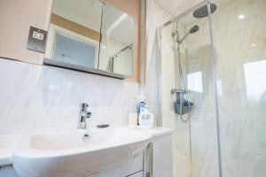 a white bathroom with a sink and a shower at Stylish 3-Bed, Garden & Secure Parking - M5 5 mins in Hindlip +28 photos