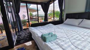 a bed in a room with a large window at อินทนนท์ บ้านพักเล่าจู Inthanon Laoju House in Ban Na Yang +5 photos