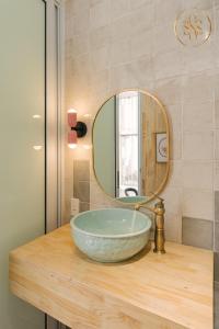 a bathroom with a bowl sink and a mirror at Sunny House 3Brs Hoan Kiem Lake by SSens in Hanoi