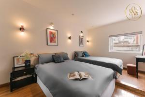 a bedroom with two beds and a clock on the wall at Sunny House 3Brs Hoan Kiem Lake by SSens in Hanoi