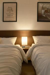 une chambre avec deux lits et une table avec une lampe dans l'établissement Walking Distance to Sindorim Station, 3 Rooms, 4 Queen Beds, 2 Bathrooms, 1 Minute to Yeongdeungpo Station Bus Stop, à Séoul 15 autres photos