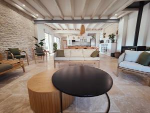 a living room with couches and a table at Domaine Saint Loup - Chambres d'hôtes in Saint-Loup-Géanges