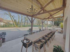 a large wooden table and chairs under a pavilion at Domaine Saint Loup - Chambres d'hôtes in Saint-Loup-Géanges