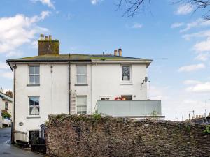 a white house with a fence in front of it at Friday Cottage - Brixham in Brixham