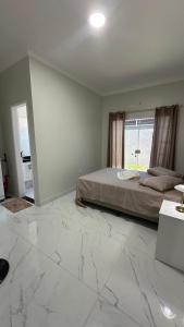 a bedroom with a bed and a large marble floor at Paracuru casa temporada Villa Ariane in Paracuru +49 photos
