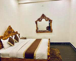 a bedroom with a bed with a mirror on the wall at Mewar Lodge in Varanasi