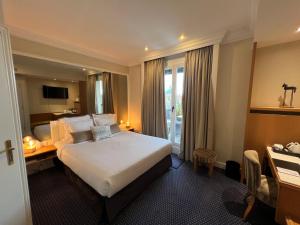 Una habitación de hotel con una cama grande y un escritorio. en Maison LUTETIA R, en Estrasburgo