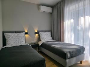 a bedroom with two beds and a window at W64 Apartamenty in Płock
