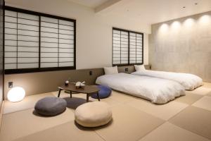 a bedroom with two beds and a table and windows at Miyajima Coral Hotel in Miyajima +86 photos