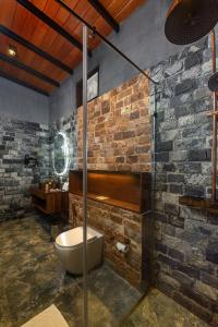 bagno con servizi igienici e parete in pietra di Atha Resort a Sigiriya Altre 37 foto